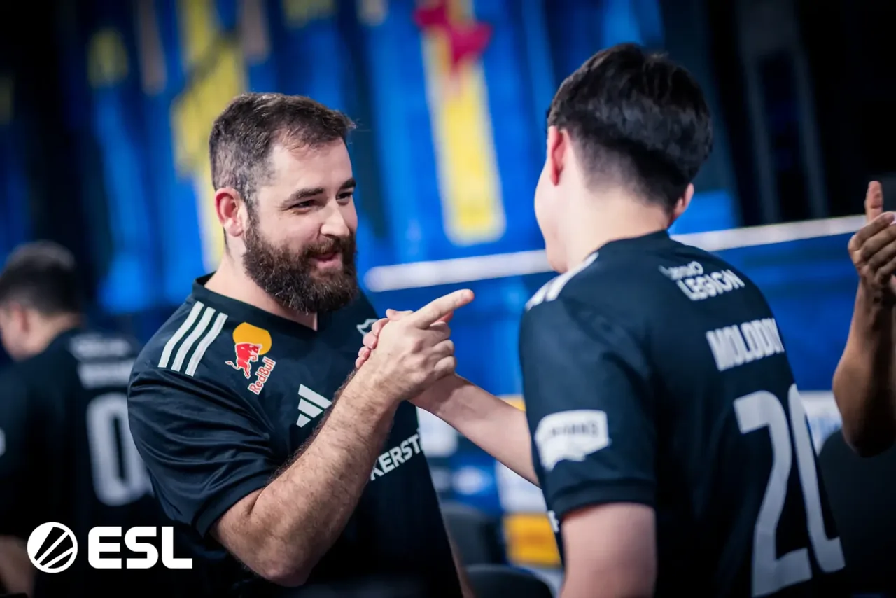 FalleN sorrindo e cumprimentando molodoy, os dois com a camisa preta da FURIA, num palco da ESL